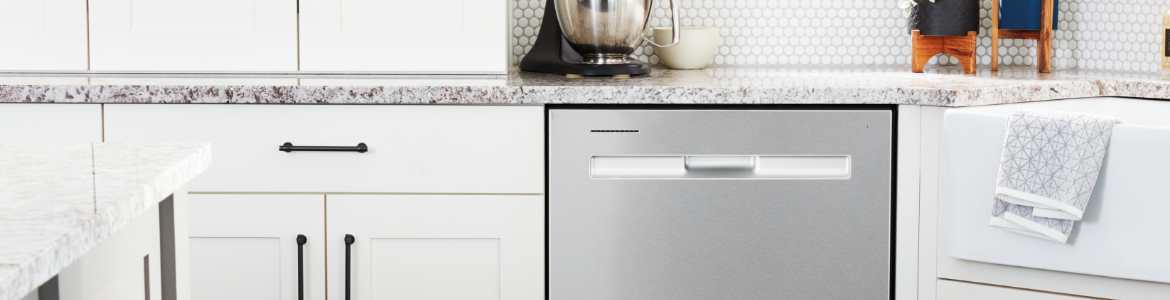A kitchen with a Maytag Dishwasher next to a white sink. On the counters are potted plants, a KitchenAid Stand Mixer and hand soap. 