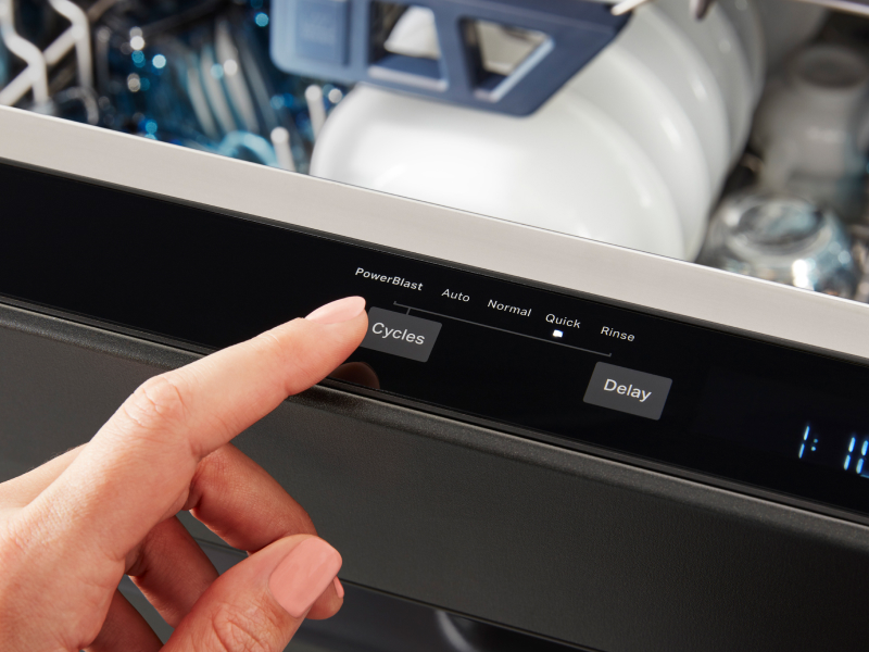 Person selecting a cycle on a dishwasher.