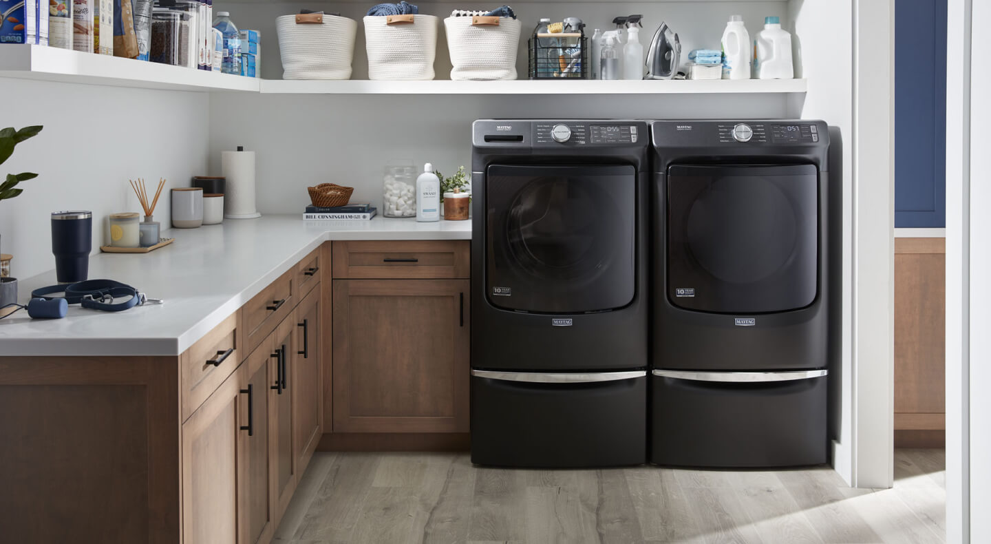 Une laveuse et une sécheuse Maytag® côte à côte dans une salle de lavage moderne.