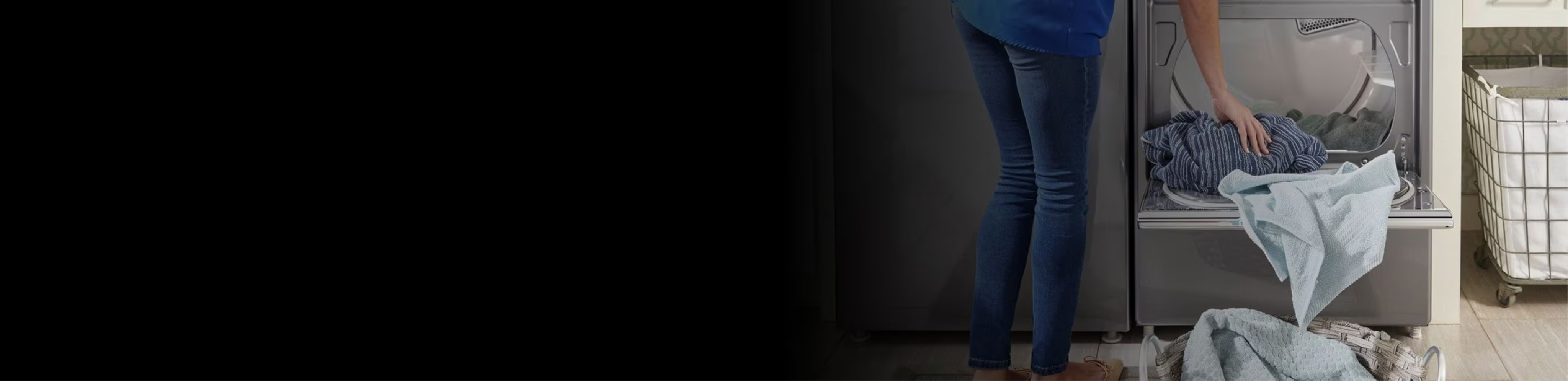 A woman stands next to an opened Whirlpool Dryer. On the dryer's door are articles of clothing, some of which have fallen on the floor