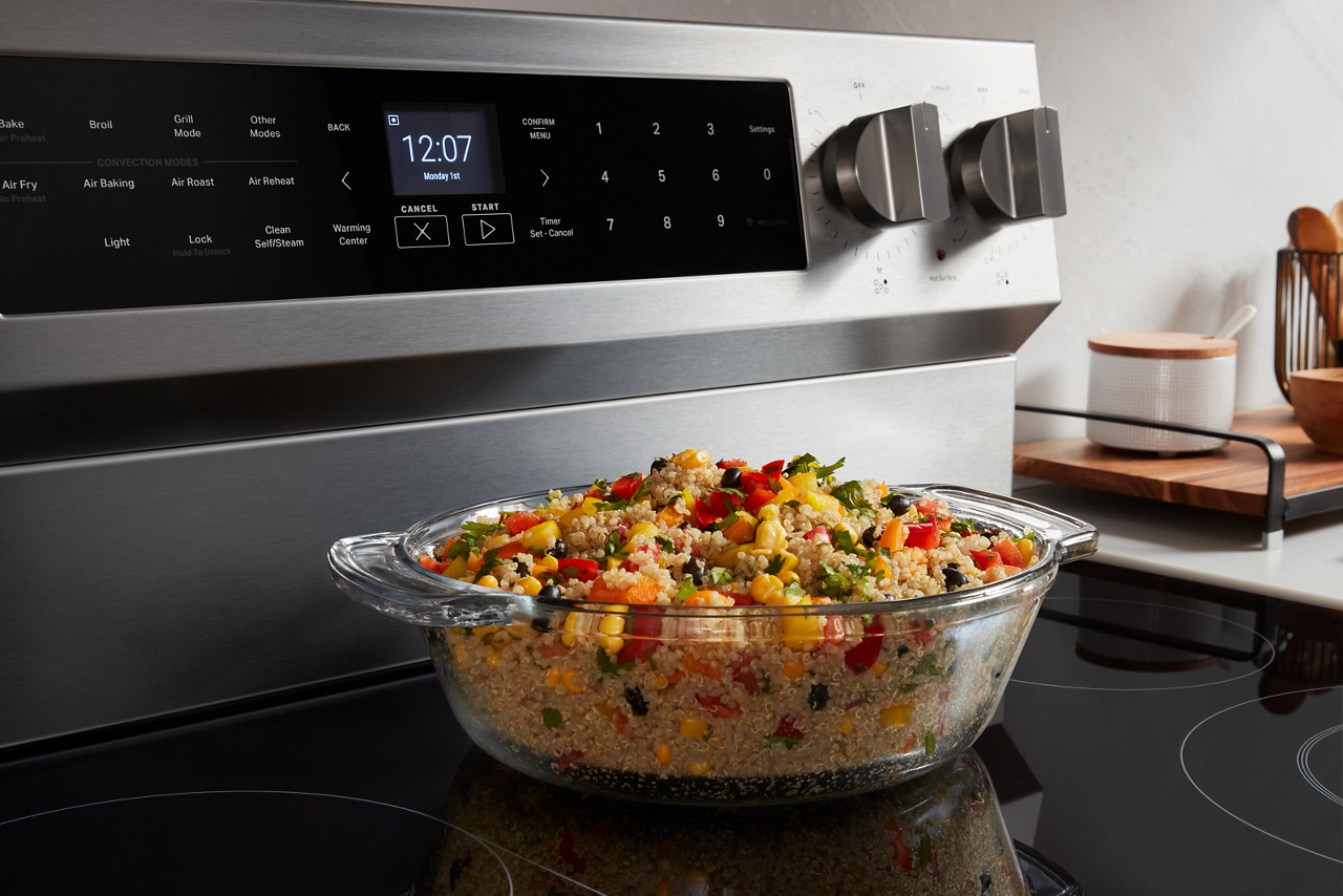 Quinoa with vegetables in a baking dish on a Maytag Stove.