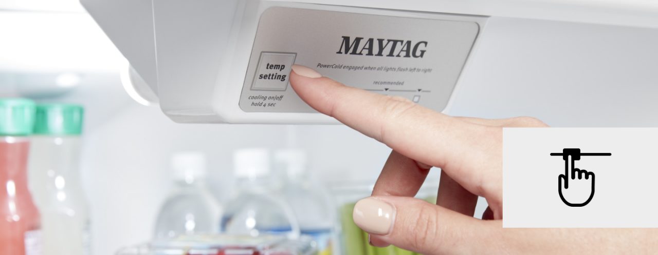 Hand pressing Maytag Fridge temperature settings button 