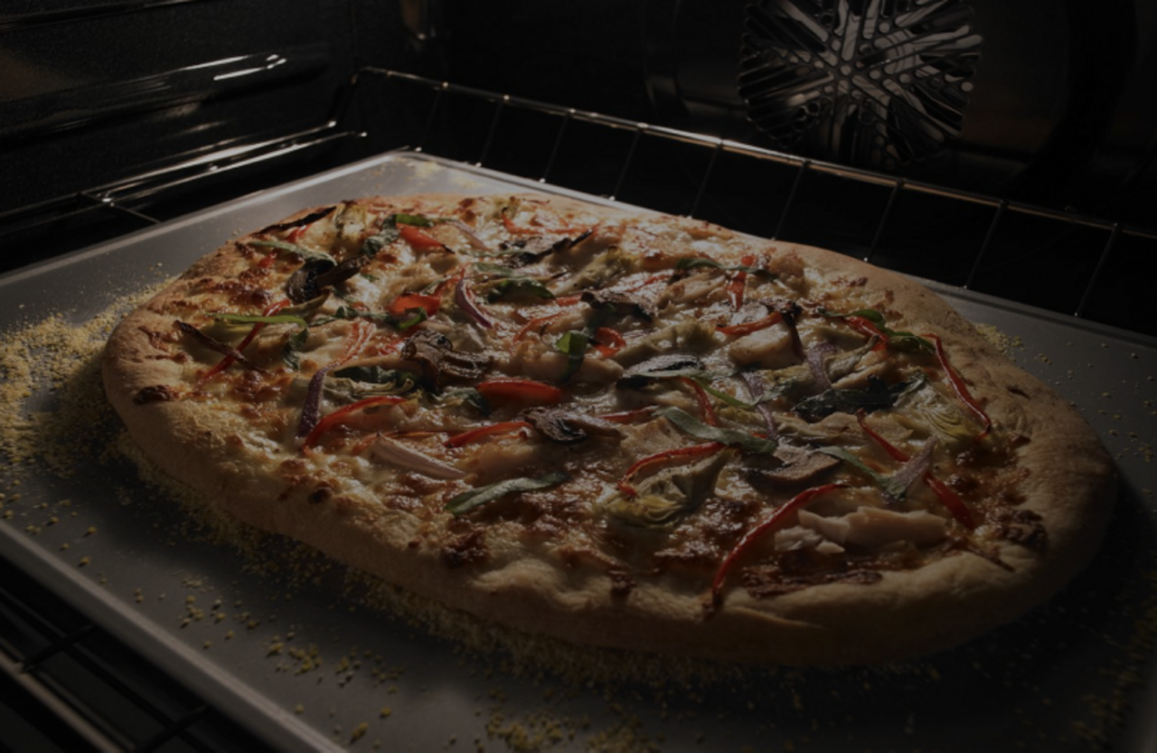 A pizza cooking inside a conventional oven A pizza cooking inside a conventional oven