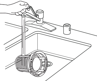A person cleaning a dishwasher filter by rinsing it under a faucet A person cleaning a dishwasher filter by rinsing it under a faucet