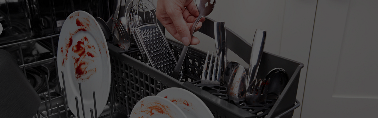 Hand loading silverware into a dishwasher