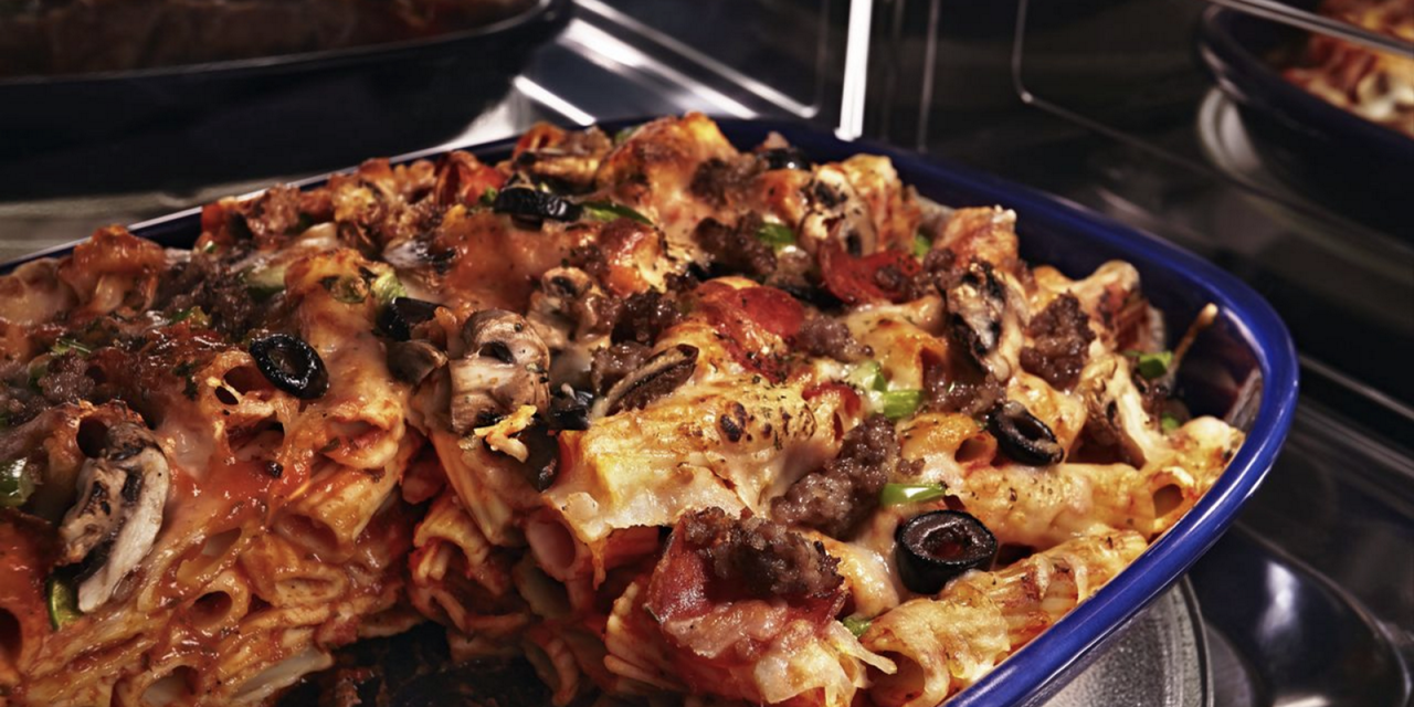 A pasta bake in a blue dish inside a convection microwave. A pasta bake in a blue dish inside a convection microwave.