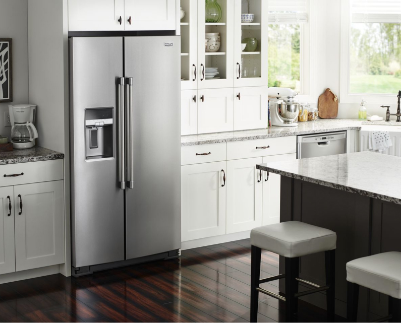 A side-by-side counter-depth refrigerator aligns with the edge of the countertops in a white kitchen.