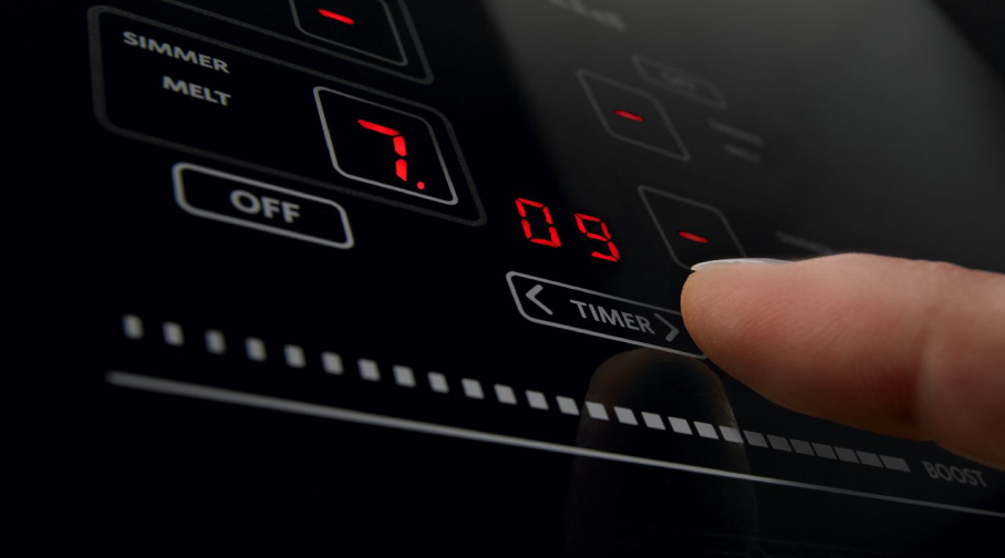 A close up image of an induction cooktop control pad. A close up image of an induction cooktop control pad.