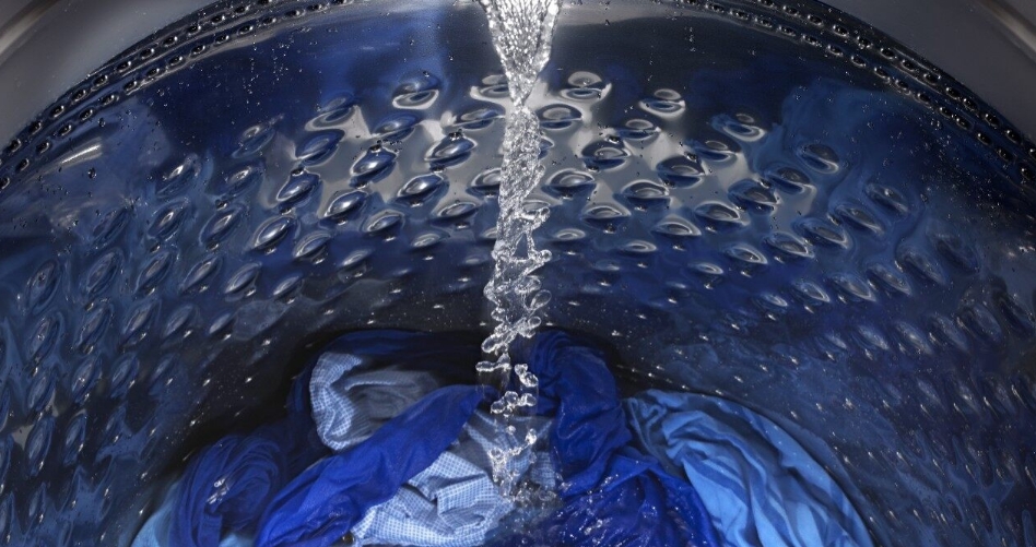The interior of a washing machine with various clothing items