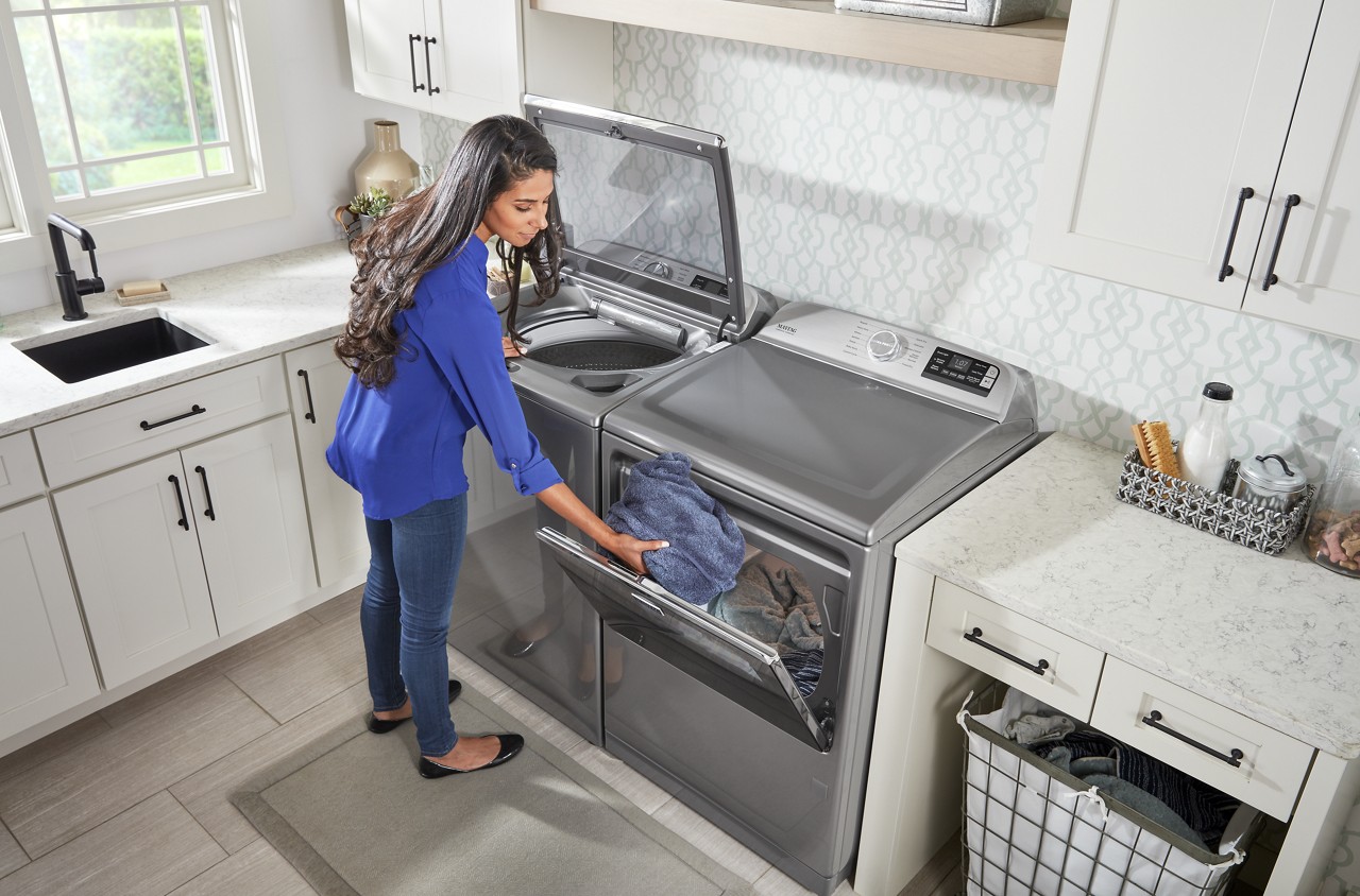 Loading clothes to a Maytag dryer. 