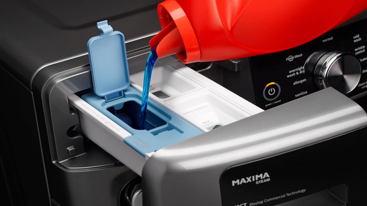 Filling a Maytag® washing machine dispenser with detergent. Filling a Maytag® washing machine dispenser with detergent.