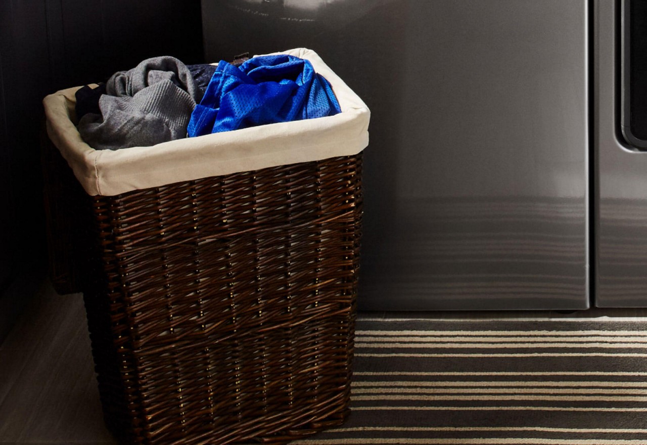 A hamper filled with laundry sorted by color. A hamper filled with laundry sorted by color.