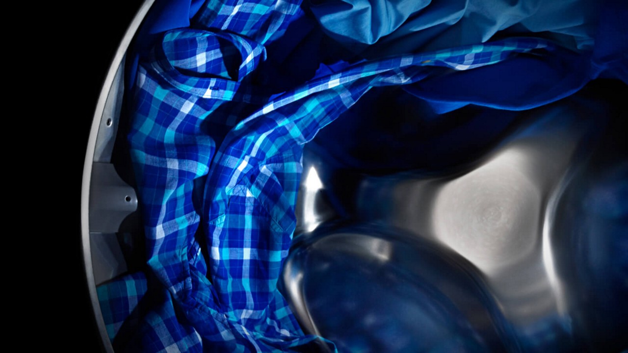 Maytag® dryer tumbling blue clothes. Maytag® dryer tumbling blue clothes.