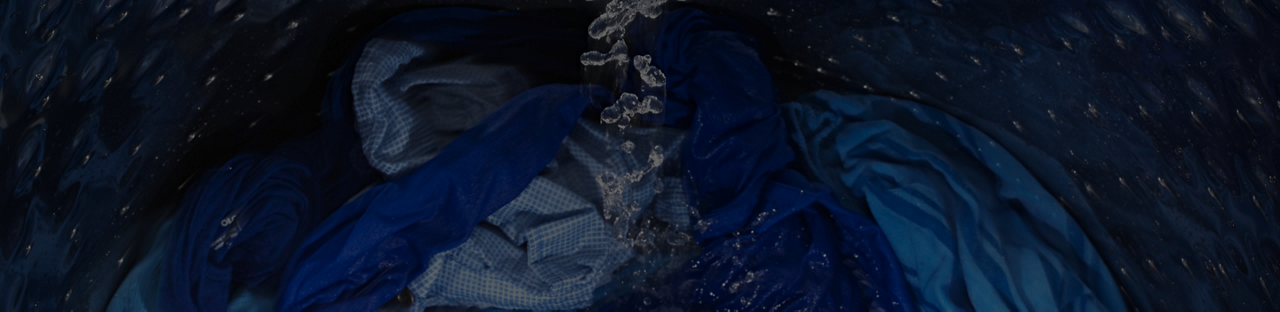 Water filling a top load washer full of shirts.