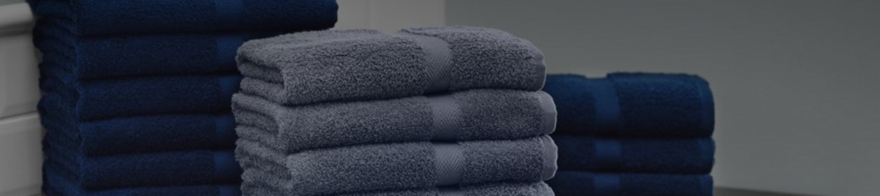 Folded blue and gray bath towels stacked in three separate piles.