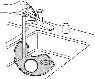 Personne nettoyant un filtre de lave-vaisselle en le rinçant sous le robinet d’eau.