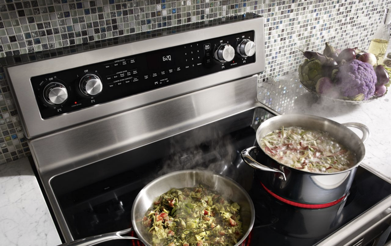 Aliments mijotant dans deux  marmites sur une surface de cuisson électrique