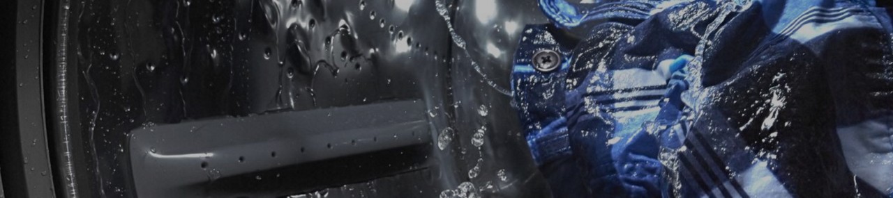 Vue intérieure d’une laveuse Maytag® lavant des vêtements.