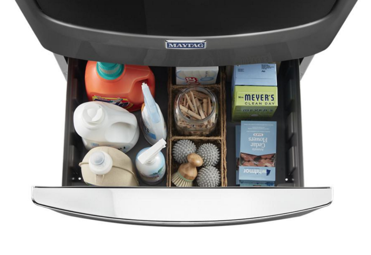 Produits de nettoyage dans un piédestal de laveuse ouvert.
