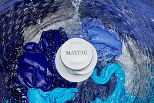 Une brassée de vêtements en train d’être lavée dans une laveuse Maytag avec plaque de lavage