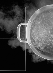 A pot of water boiling on a Maytag® cooktop