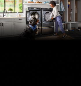 Person and a dog in front of a Maytag® front load washer and dryer