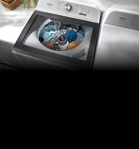 Person and a dog in front of a Maytag® front load washer and dryer