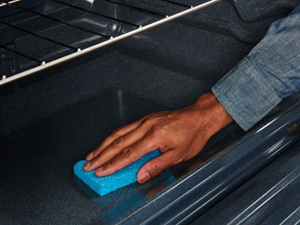 Person cleaning the interior of an oven