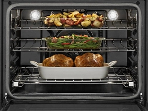  Various foods cooking in an oven on multiple racks
